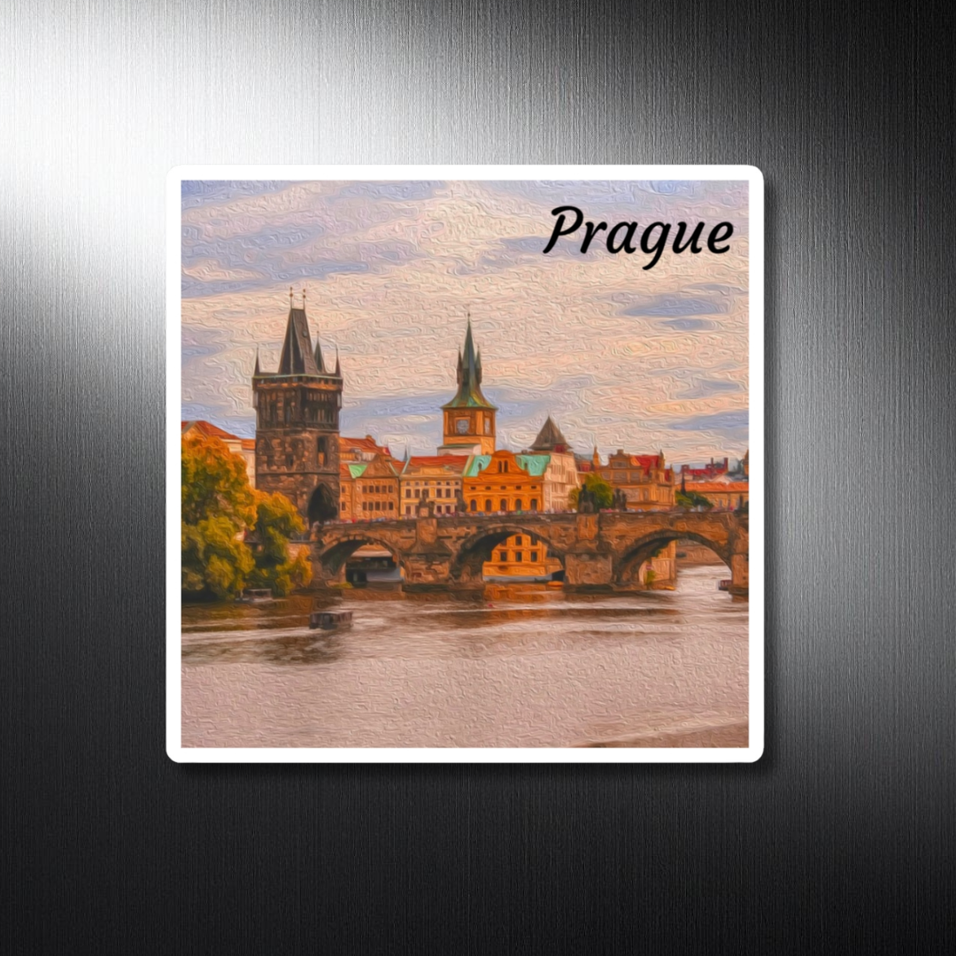 Square decorative travel magnet featuring a watercolor of Charles Bridge, Prague — Gothic tower, terracotta rooftops and verdigris copper domes above the Vltava in warm autumn light. The Painted Passport Original Series.